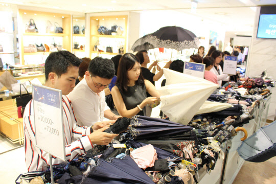 29일 서울 소공동 롯데백화점 본점 잡화매장에서 고객들이 양산을 고르는 모습. <롯데백화점 제공>